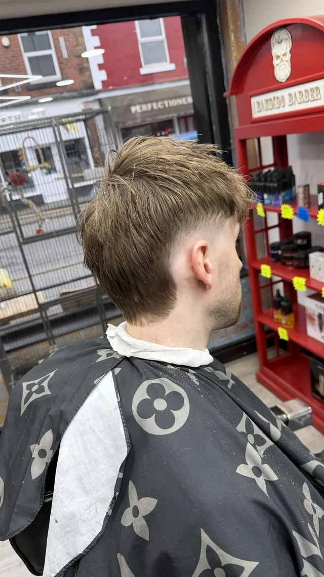 Back and side view of a longer light-brown haircut with a tidy neckline